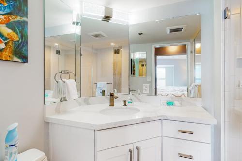 Baño blanco con lavabo y espejo grande en Serene in Seattle en Seattle