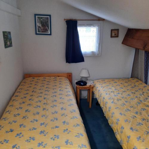 - 2 lits dans une petite chambre avec fenêtre dans l'établissement Ambiance-Provence, à Vidauban