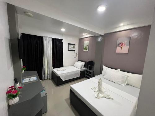 ein Hotelzimmer mit 2 Betten und einem Schreibtisch in der Unterkunft Oceanlodge El Nido in El Nido