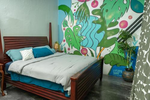 サンファンにあるCasa Vibe San Juan Great for large groupsのベッドルーム1室(壁に絵画が描かれたベッド1台付)