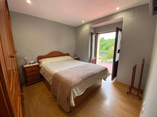 a bedroom with a large bed and a window at La Casa de Anita y José in Colunga