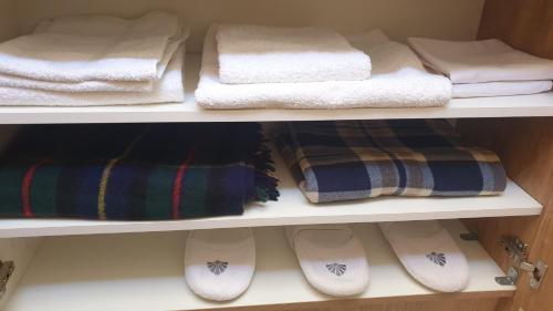 a closet with towels and slippers on a shelf at Mikhail Zandukeli 34 Studio in Tbilisi City