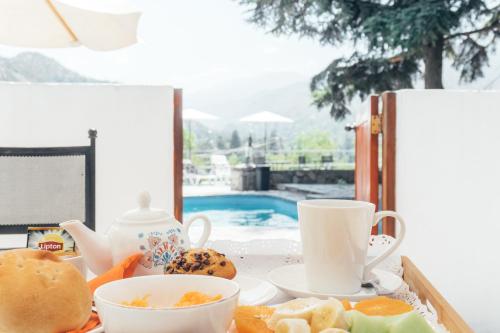 uma bandeja de comida com chávenas de chá e biscoitos em Casa Arrayán em Santiago