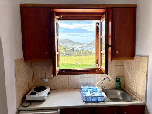 a kitchen with a sink and a window with a view at Nicolas Studios in Skala