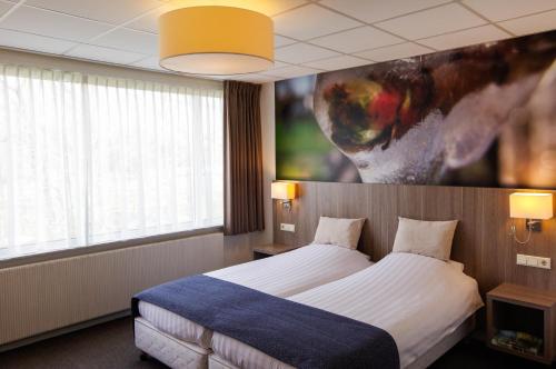 a hotel room with a bed and a painting on the wall at Hotel and Restaurant van Saaze in Kraggenburg