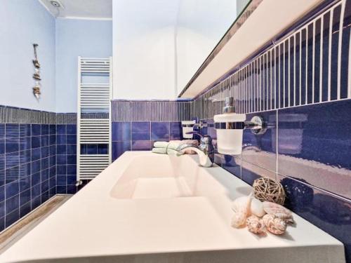 a bathroom with a white sink and blue tiles at Villa Galatea Stella Marina in Capoliveri