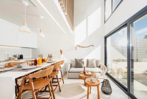 una cucina e un soggiorno con tavolo e sedie di Serene seafront villas a Nea Iraklia