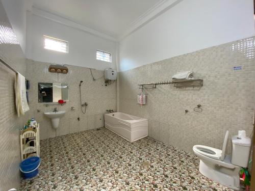 a bathroom with a toilet and a sink and a tub at Tom Homestay in Yên Minh