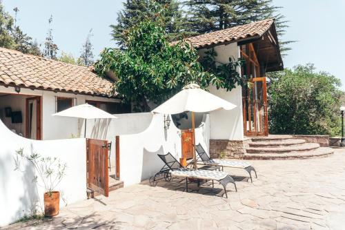 a house with two chairs and two umbrellas at Casa Arrayán in Santiago