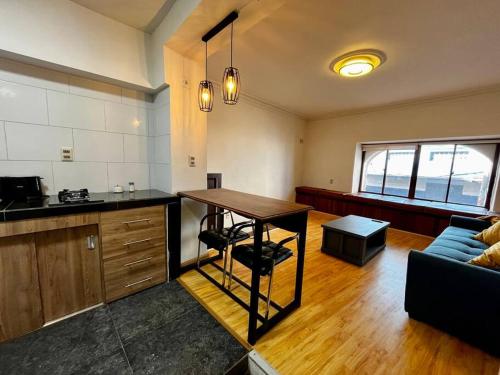 eine Küche und ein Wohnzimmer mit einem Tisch und einer Couch in der Unterkunft Departamento en La Paz, en pleno centro histórico in La Paz