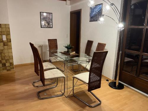 a dining room with a glass table and chairs at Geräumige Ferienwohnung 90 sqm im Erholungsort in Bestwig
