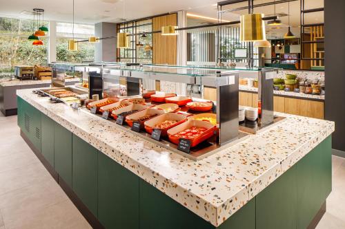 a kitchen with a counter with food on it at Holiday Inn Manchester Airport T2 by IHG in Hale