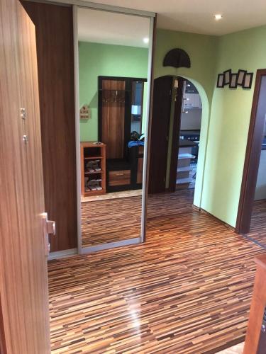 a room with a mirror and a wooden floor at Apartman Gufo in Kysucké Nové Mesto