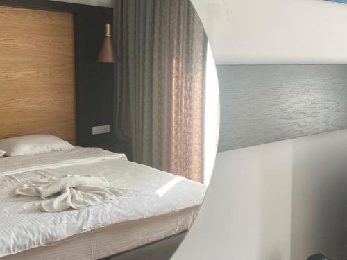 a bedroom with a bed with white sheets and a window at On Oda Oludeniz in Oludeniz