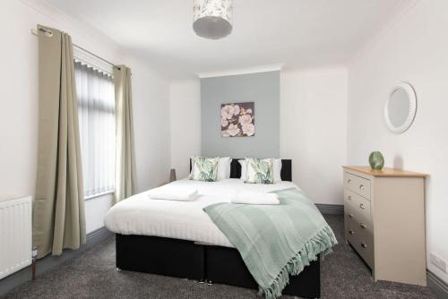 a bedroom with a large bed and a dresser at 26 Station in Ushaw Moor