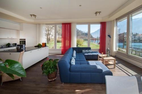 a living room with a blue couch and a kitchen at Aparthotel Goldey in Interlaken
