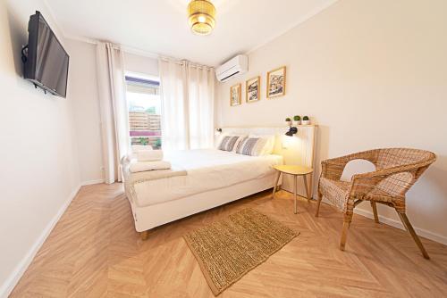 Un dormitorio con una cama, un televisor y una silla. en CityLiving, en Oporto