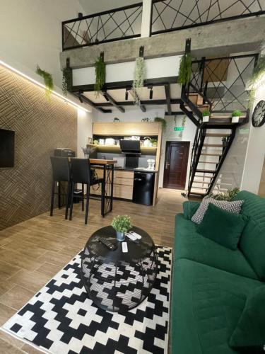 a living room with a green couch and a table at Apartman Plaža Lux in Veliko Gradište
