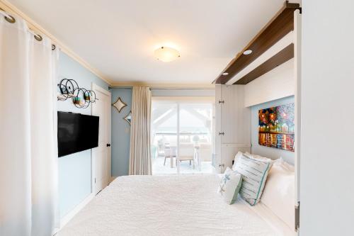 um quarto com uma cama grande e uma televisão em Palapa House em Panama City Beach