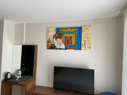 a living room with a tv and a painting on the wall at On Oda Oludeniz in Oludeniz