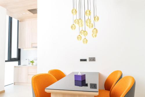 a dining room with orange chairs and a table at Capri by Fraser, Phnom Penh in Phnom Penh