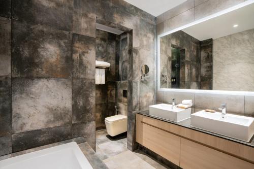 a bathroom with two sinks and a mirror at Capri by Fraser, Phnom Penh in Phnom Penh