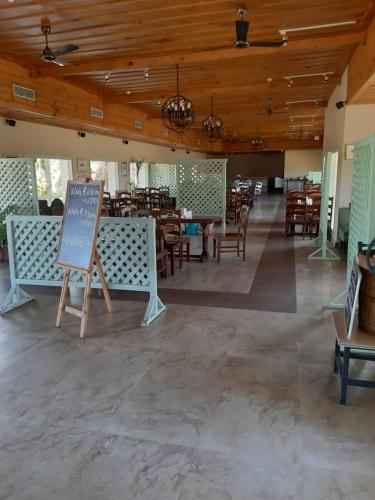 a restaurant with tables and chairs and a chalkboard at Hotel Sarai Bharatgarh in Chandīgarh