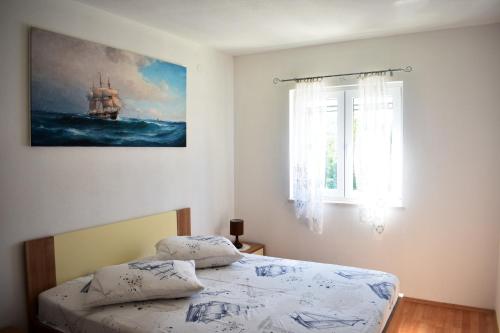 a bedroom with a bed and a painting on the wall at One bedroom appartement at Slatine 250 m away from the beach with sea view enclosed garden and wifi in Slatine