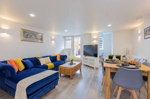 a living room with a blue couch and a table at Central Windsor Modern Garden Flat, Walk 2 Sights - By Tempstay in Windsor