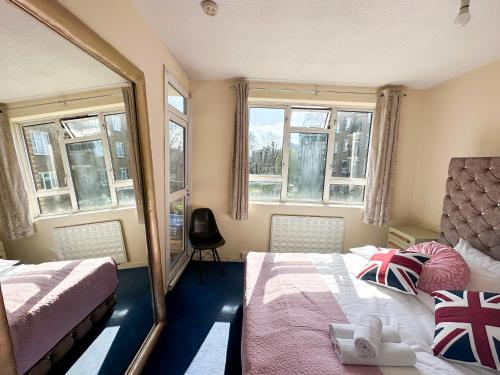 1 dormitorio con 2 camas y 2 ventanas en Flat 21, en Londres