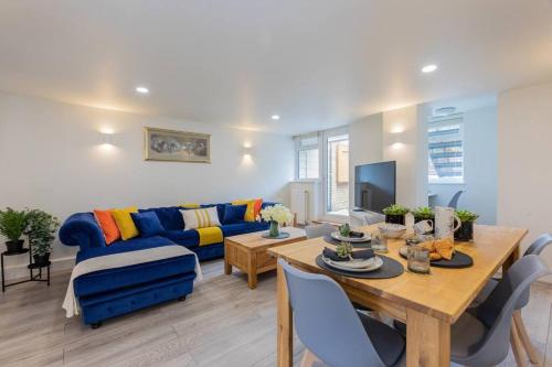 a living room with a blue couch and a table at Central Windsor Modern Garden Flat, Walk 2 Sights - By Tempstay in Windsor