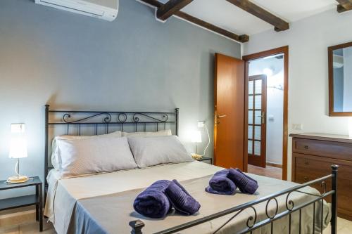 um quarto com uma cama com almofadas roxas em Villetta Brezza Marina em Porto Ercole