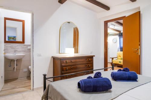 um quarto com uma cama, um lavatório e um espelho em Villetta Brezza Marina em Porto Ercole