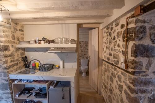 cocina con fregadero y pared de piedra en το σπίτι του δάσκαλου- teacher's house, en Sirako