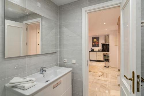 een witte badkamer met een wastafel en een spiegel bij P2B - Casa Paraiso by Roomservices in Estepona