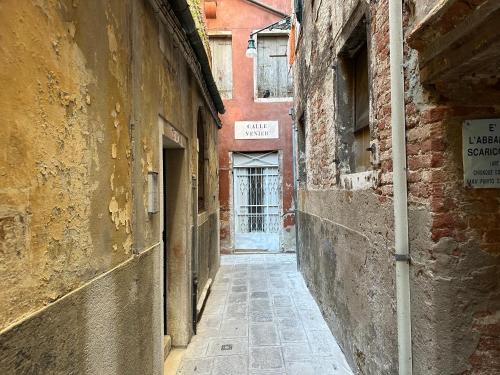 an alley in an old building with a door in the distance at San Marco Luxury Loft with Terrace in Venice