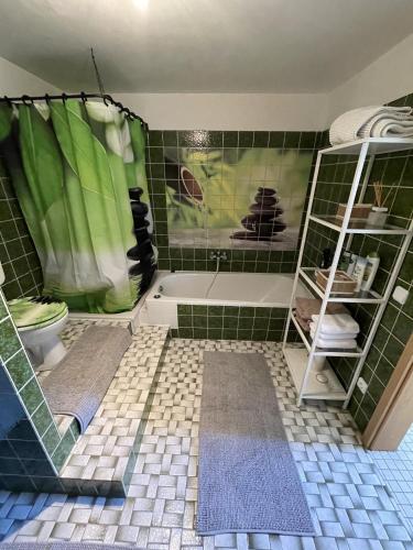 a bathroom with a green tiled floor and a bath tub at Apartment Isenbügel / Essen-Kettwig in Heiligenhaus
