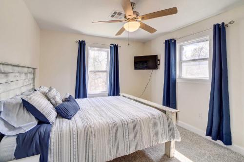 a bedroom with a bed with blue curtains and a ceiling fan at Pet-Friendly Afton Vacation Rental with Game Room in Afton