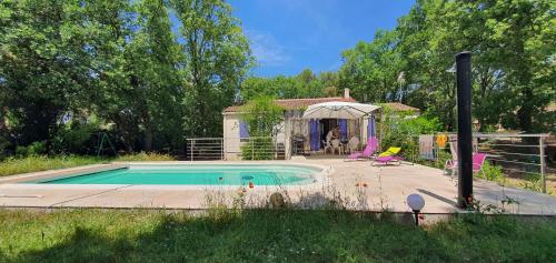 una pequeña piscina en un patio con cenador en Le chêne Vert, en Vidauban