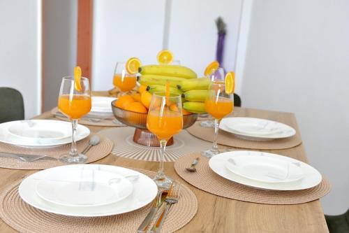 einem Holztisch mit Teller und Gläsern Orangensaft in der Unterkunft Spalato in Split