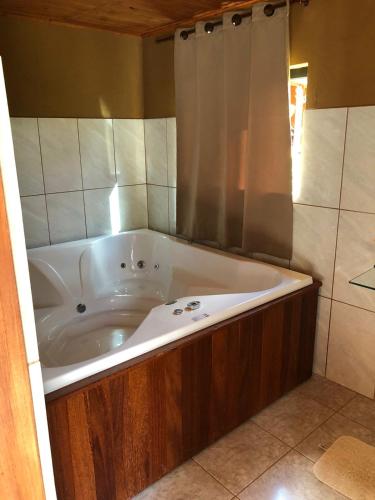 a bath tub in a bathroom with a shower at Pousada Recanto das Hortênsias in Cunha