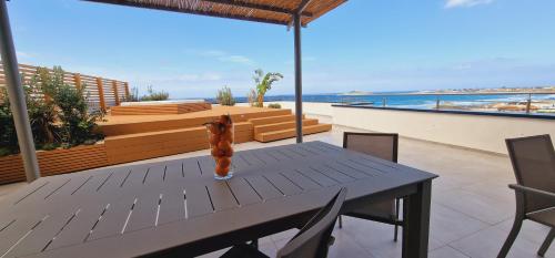 a table and chairs on a balcony with the ocean at Saracen Sands Hotel & Congress Centre - Palermo in Isola delle Femmine