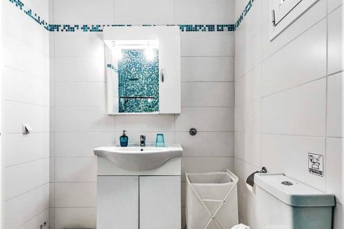 a white bathroom with a sink and a toilet at Villa Xenos Tria in Tigaki