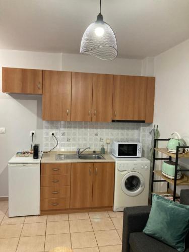 een keuken met een wastafel en een wasmachine bij M.O.M.’s in Alexandroupoli