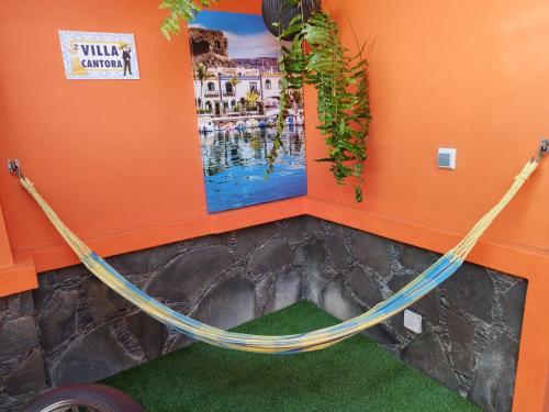 a hammock in a room with an orange wall at Villa Cantora in Telde