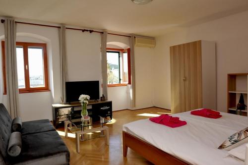 um quarto com uma cama, um sofá e uma mesa em Spalato em Split