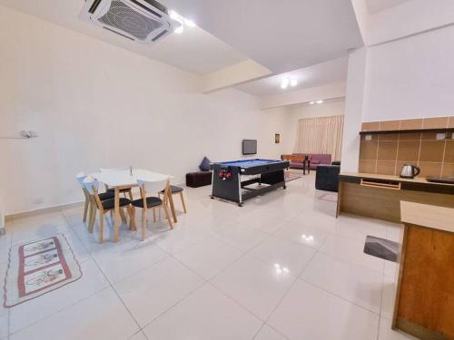 ein Wohnzimmer mit einem Tisch und einer Tischtennisplatte in der Unterkunft Cozy Party Homestay nearby Airport in Sandakan