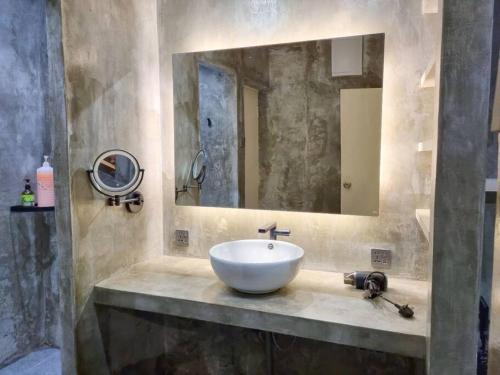 ein Badezimmer mit einem weißen Waschbecken und einem Spiegel in der Unterkunft Cozy Party Homestay nearby Airport in Sandakan