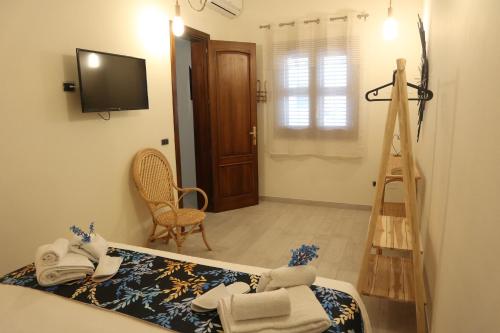 Pokój z łóżkiem, telewizorem i drabiną w obiekcie Sophia Apartments w mieście Avola