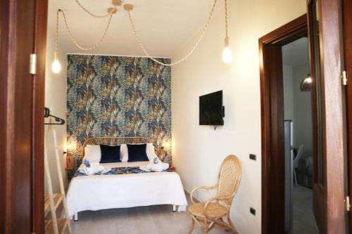 sypialnia z białym łóżkiem i niebieską wzorzystą ścianą w obiekcie Sophia Apartments w mieście Avola
